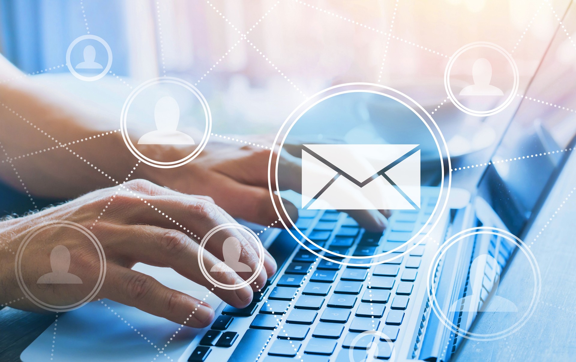 Mãos digitando em um notebook com ícones de pessoas e e-mail representando comunicação e prospecção de clientes.